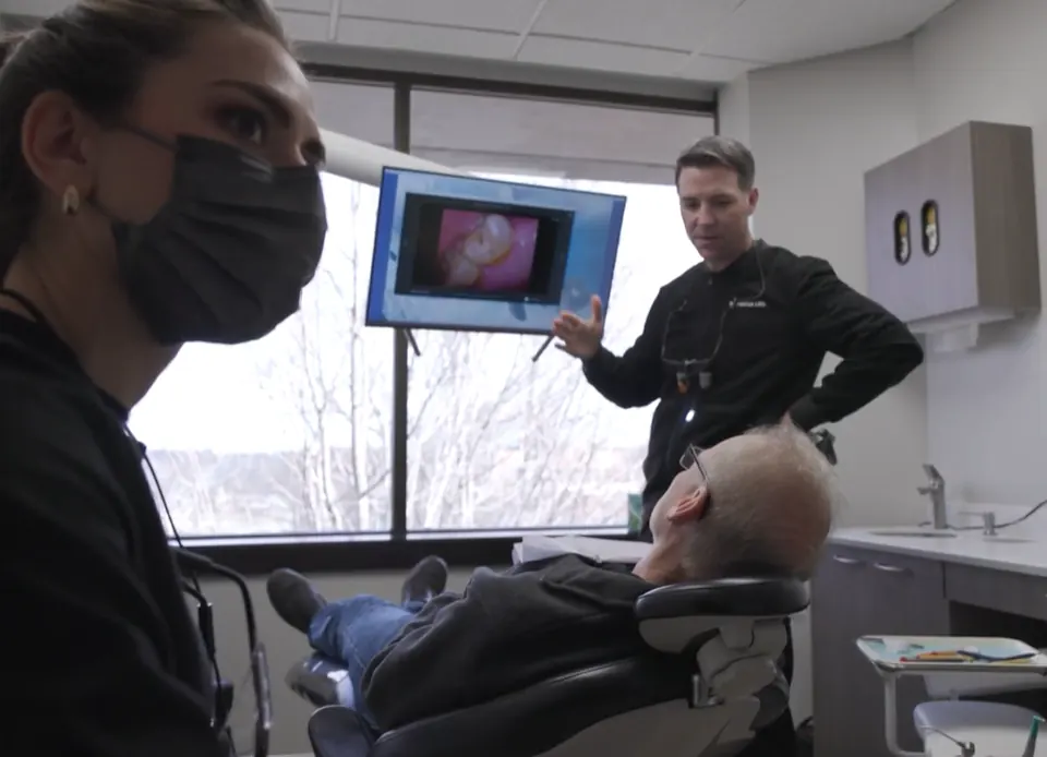 Dr. Lillis talking a patient through an intraoral image on a screen in the treatment room