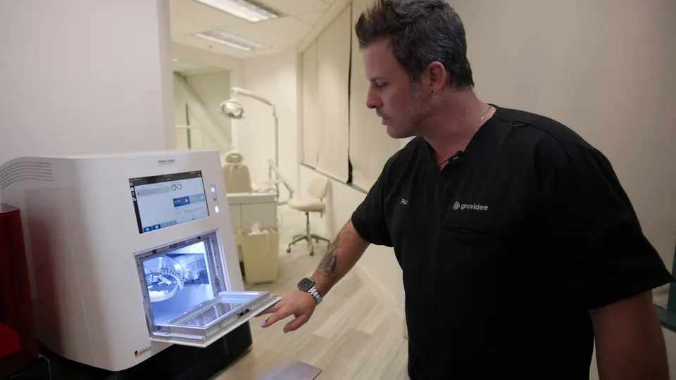 Technician checking a dental 3D printer